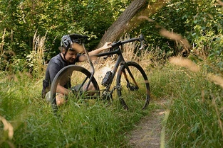 URWAHN Waldwiesel Gravel Bike E-Bike mit Mann im hohen Gras
